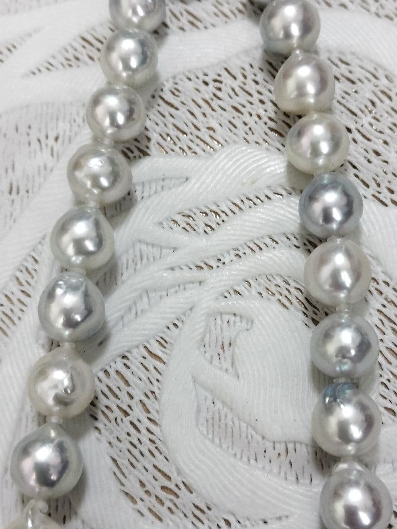 Akoya pearl large round necklace with multi-color pearls and silver push clasp on white background