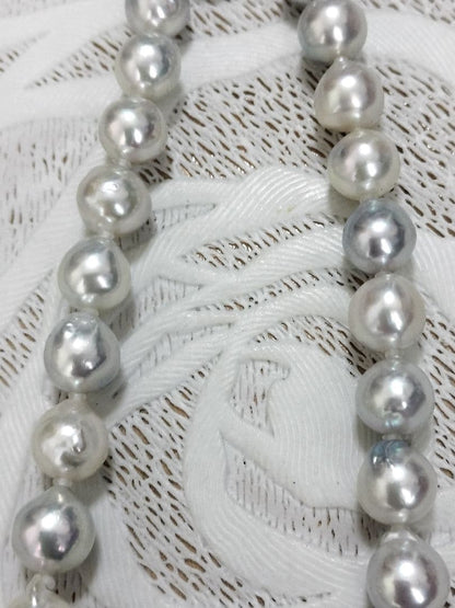 Akoya pearl large round necklace with multi-color pearls and silver push clasp on white background
