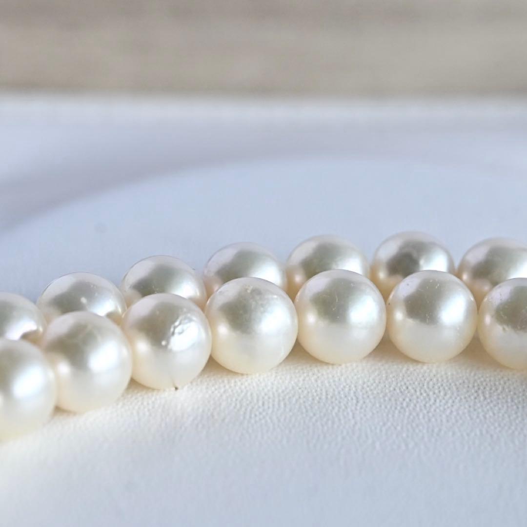 Takase Akoya pearl necklace with 7.5mm round pearls and silver ribbon clasp on a white background