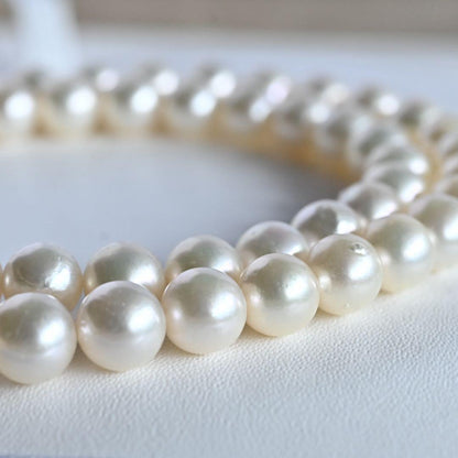 Takase Akoya pearl necklace with 7.5mm round pearls and silver ribbon clasp on a white background