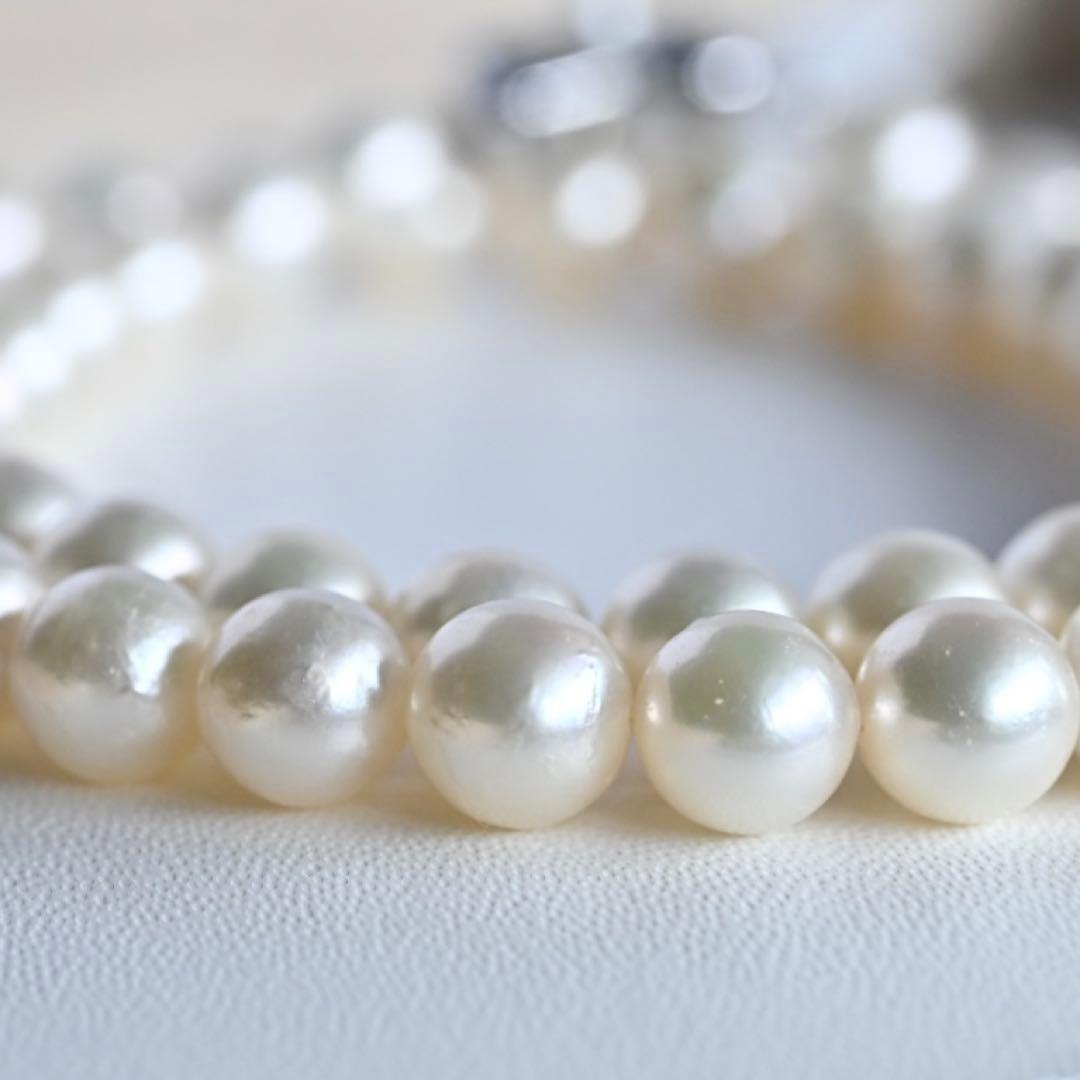 Takase Akoya pearl necklace with 7.5mm round pearls and silver ribbon clasp on a white background