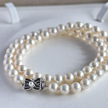 Takase Akoya pearl necklace with 7.5mm round pearls and silver ribbon clasp on a white background
