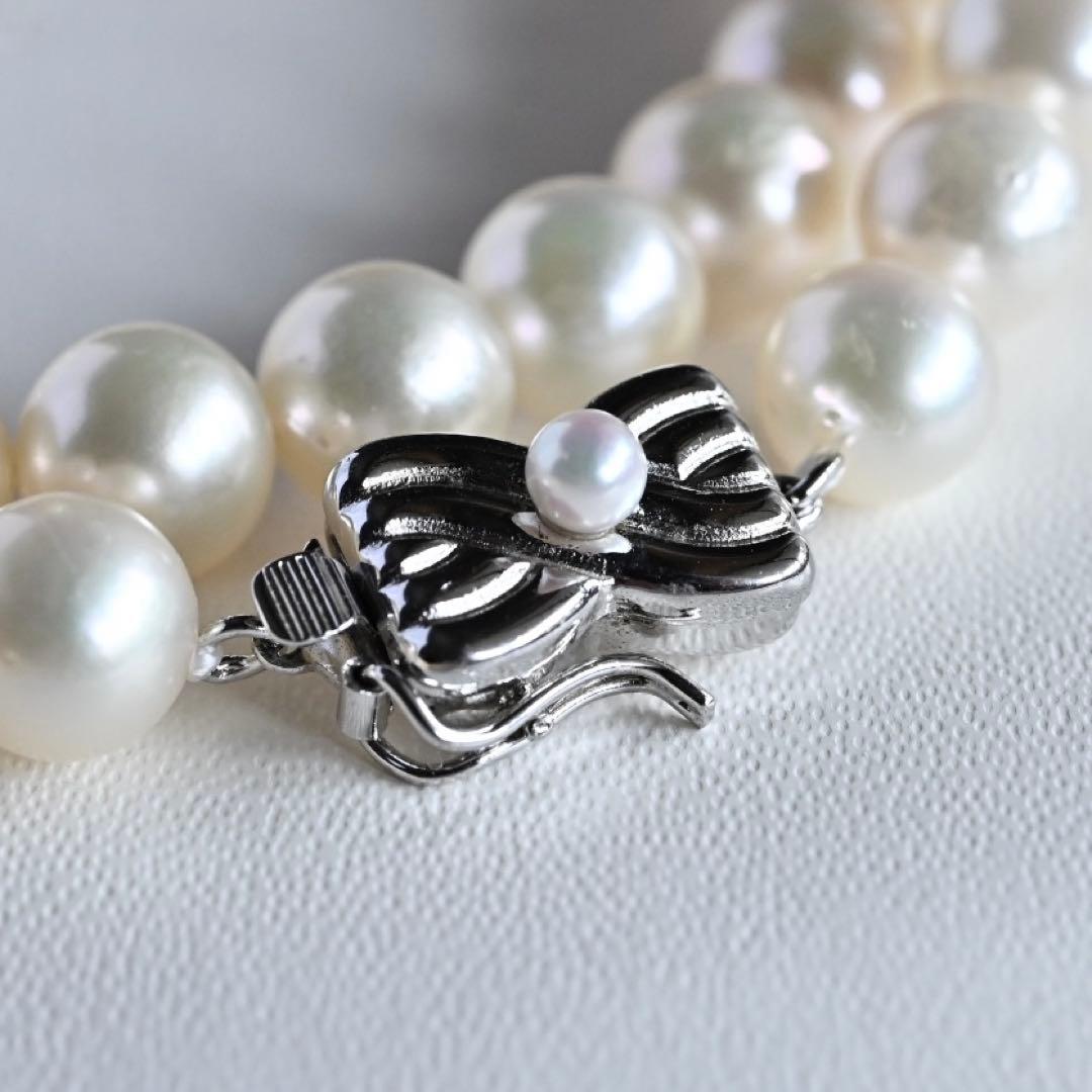 Takase Akoya pearl necklace with 7.5mm round pearls and silver ribbon clasp on a white background