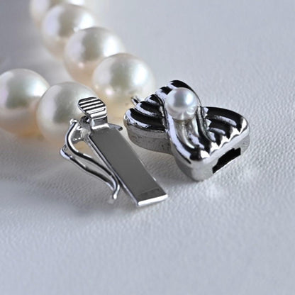 Takase Akoya pearl necklace with 7.5mm round pearls and silver ribbon clasp on a white background