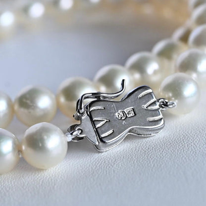 Takase Akoya pearl necklace with 7.5mm round pearls and silver ribbon clasp on a white background