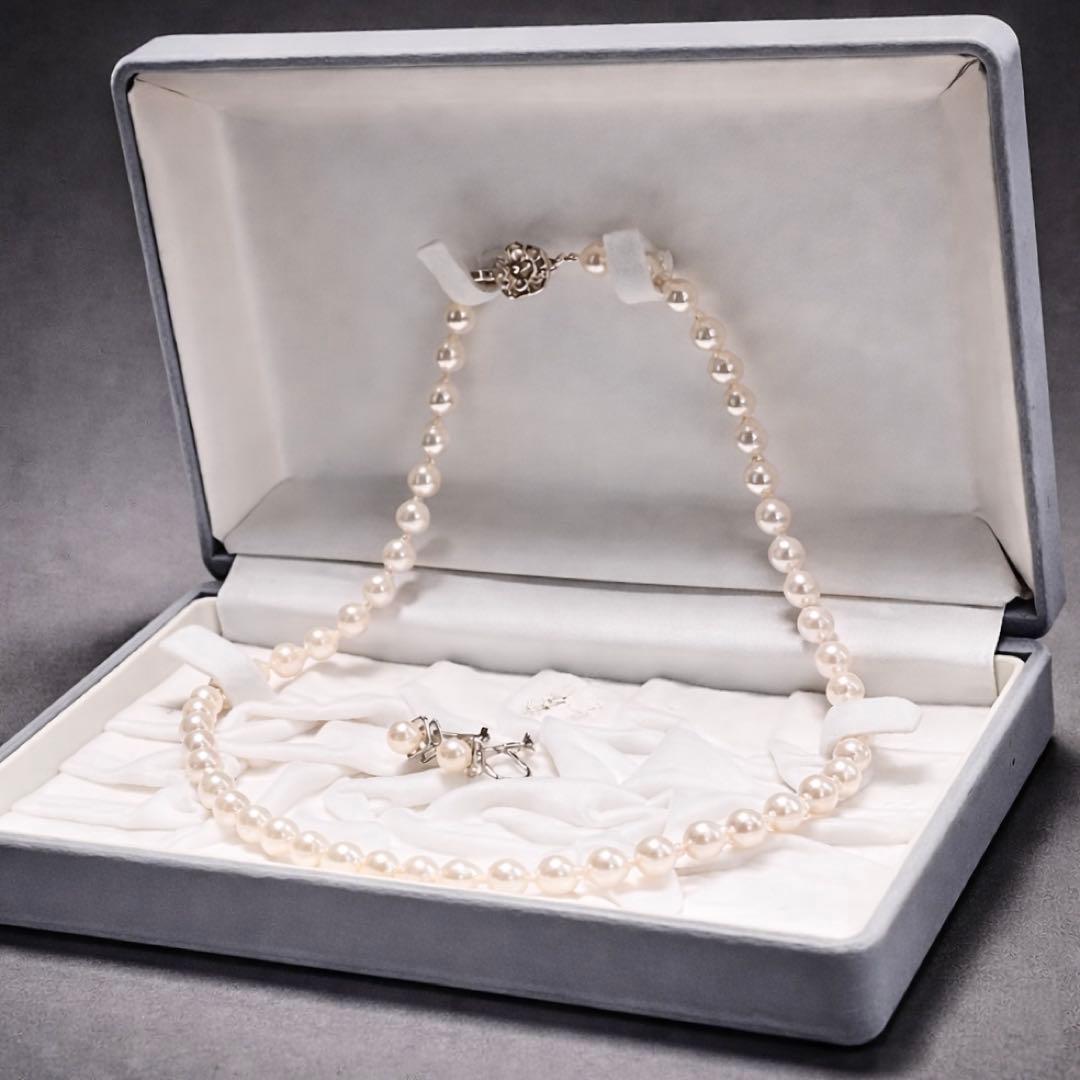 Akoya pearl necklace and matching earrings with pearls sized 6.5-7.0mm and 6.1mm on white background