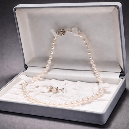 Akoya pearl necklace and matching earrings with pearls sized 6.5-7.0mm and 6.1mm on white background