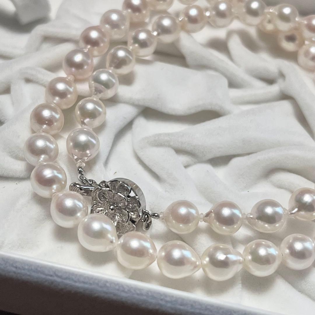 Akoya pearl necklace and matching earrings with pearls sized 6.5-7.0mm and 6.1mm on white background