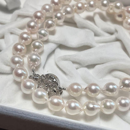 Akoya pearl necklace and matching earrings with pearls sized 6.5-7.0mm and 6.1mm on white background