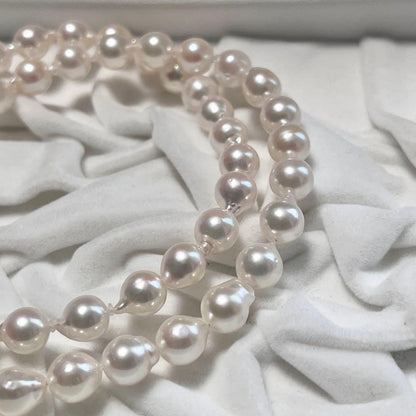 Akoya pearl necklace and matching earrings with pearls sized 6.5-7.0mm and 6.1mm on white background