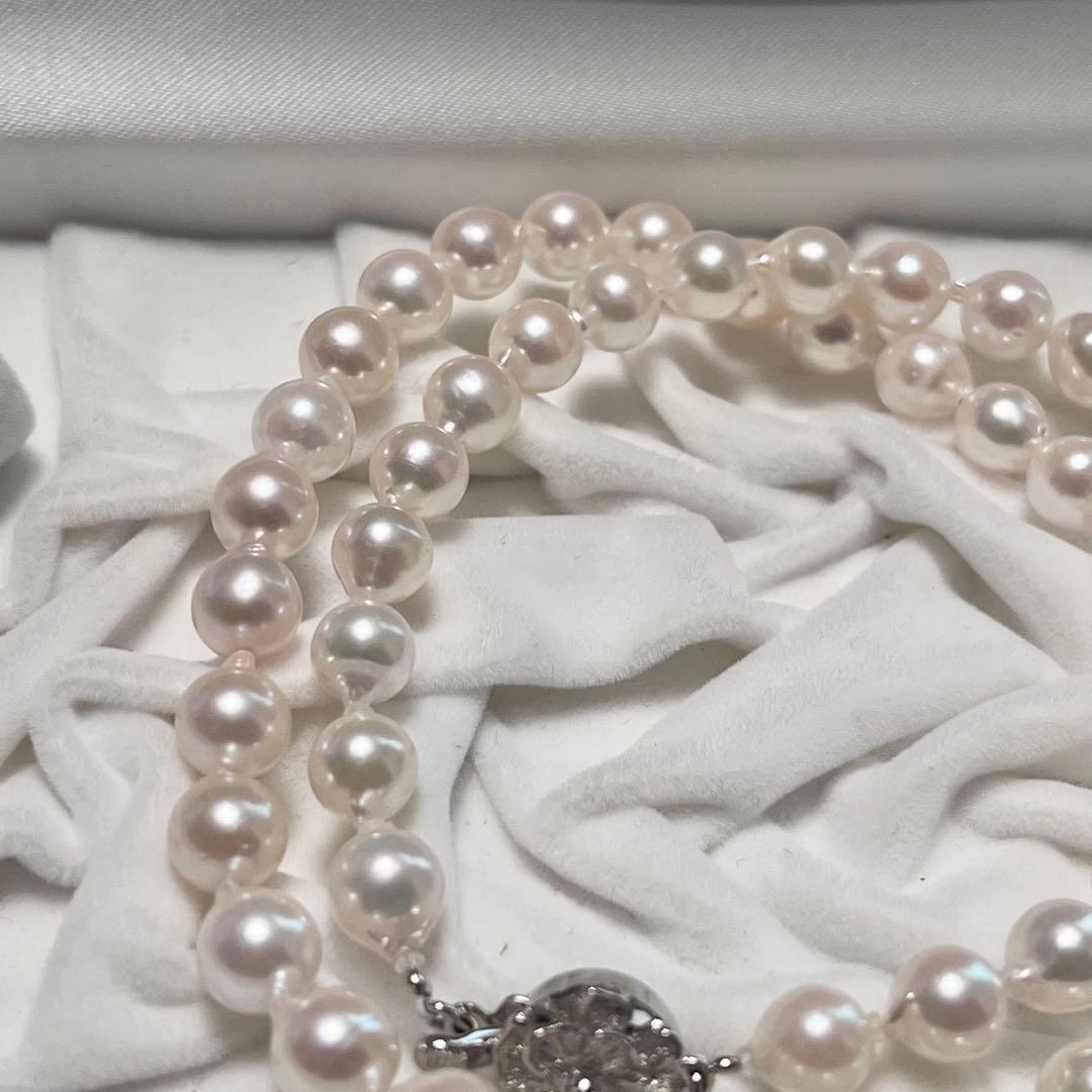 Akoya pearl necklace and matching earrings with pearls sized 6.5-7.0mm and 6.1mm on white background