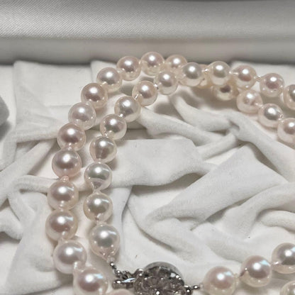 Akoya pearl necklace and matching earrings with pearls sized 6.5-7.0mm and 6.1mm on white background