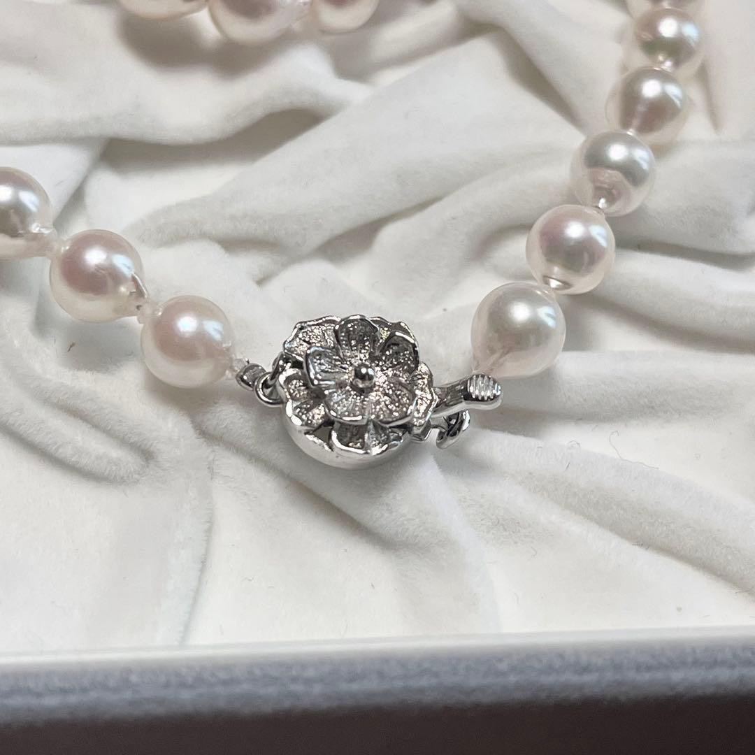Akoya pearl necklace and matching earrings with pearls sized 6.5-7.0mm and 6.1mm on white background