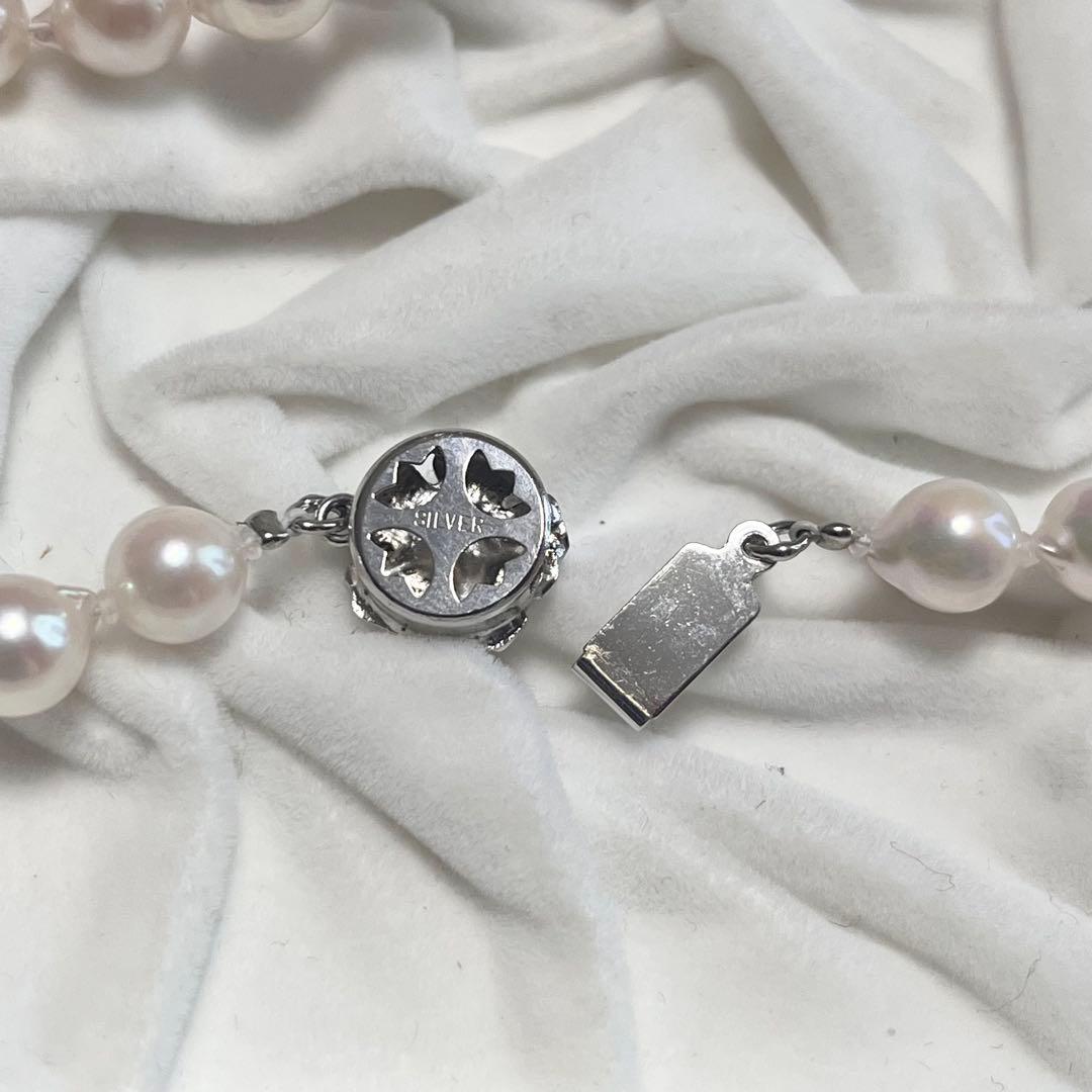 Akoya pearl necklace and matching earrings with pearls sized 6.5-7.0mm and 6.1mm on white background