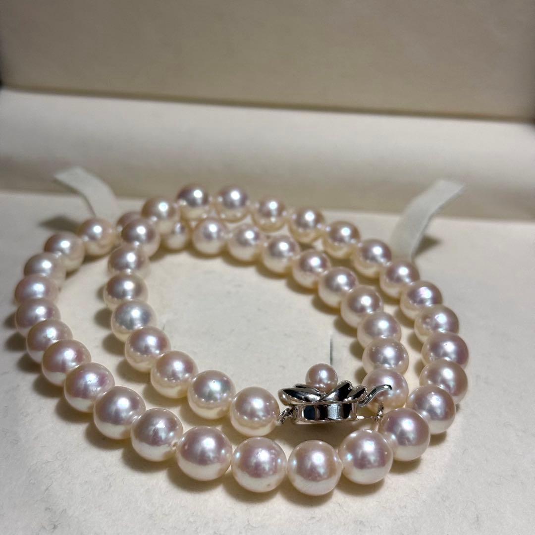 Tasaki Akoya pearl necklace with 9.0 mm pink pearls and silver closure on a white background