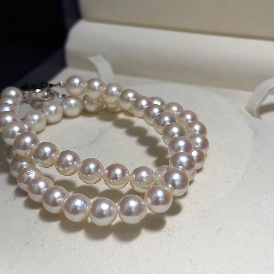Tasaki Akoya pearl necklace with 9.0 mm pink pearls and silver closure on a white background