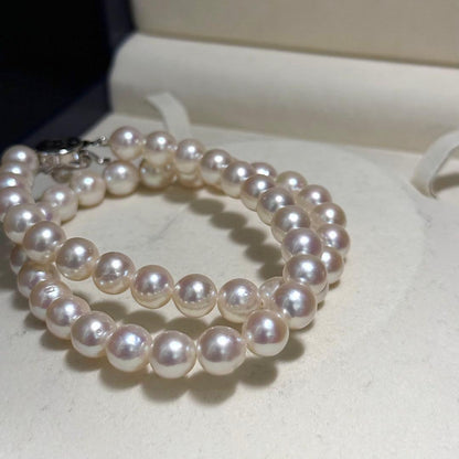 Tasaki Akoya pearl necklace with 9.0 mm pink pearls and silver closure on a white background