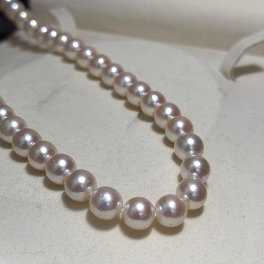 Tasaki Akoya pearl necklace with 9.0 mm pink pearls and silver closure on a white background