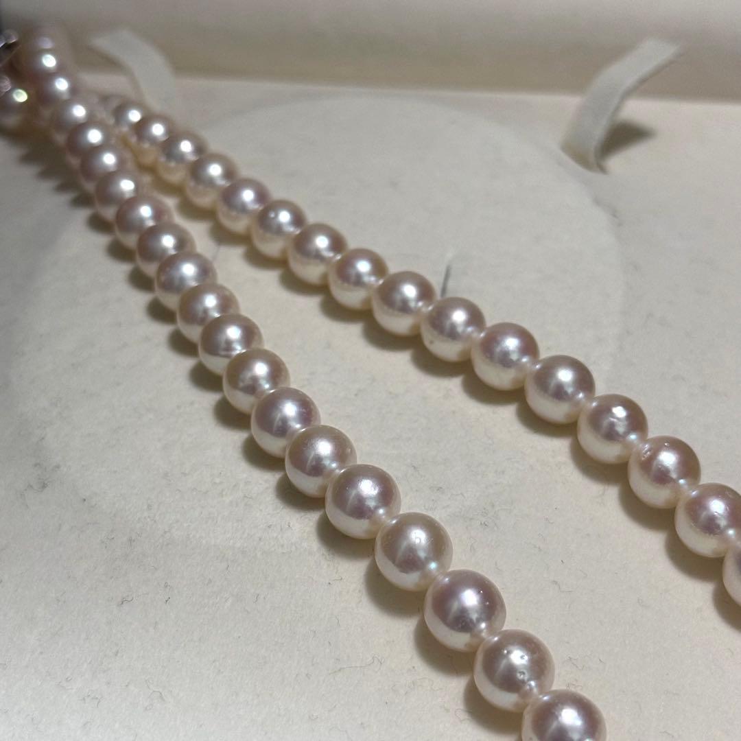 Tasaki Akoya pearl necklace with 9.0 mm pink pearls and silver closure on a white background