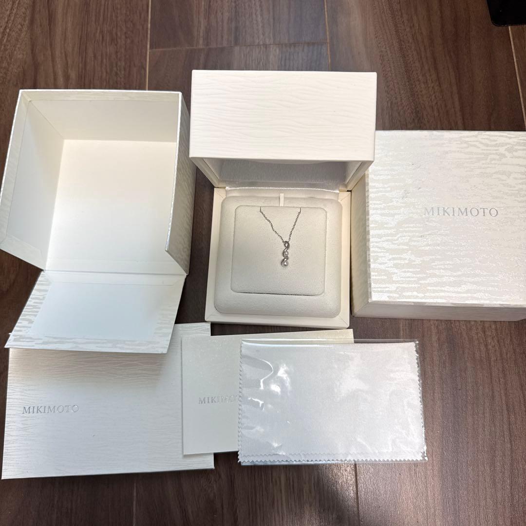 Mikimoto pearl necklace made of 18K white gold displayed on a white background