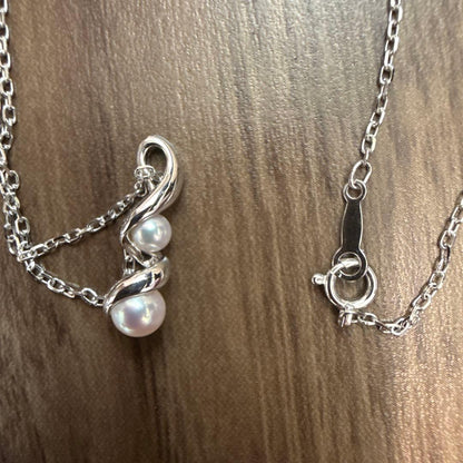 Mikimoto pearl necklace made of 18K white gold displayed on a white background