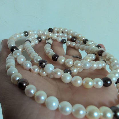 Akoya pearl long necklace with white and cream pearls sized 5.5 to 7 mm showing natural dents and wrinkles