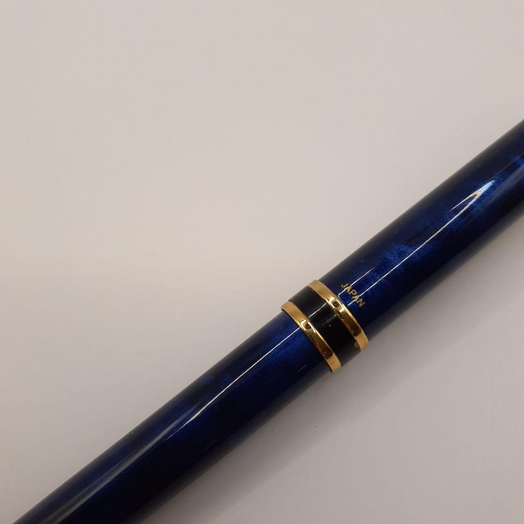 Used Pilot ballpoint pen in blue marble pattern with visible small scratches and paint chips