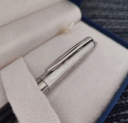 WATERMAN Paris ballpoint pen with silver wave pattern cap and black body beside a blue gift box