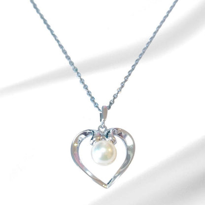 Mikimoto pearl necklace with silver heart pendant and 37 cm Akoya pearls on white background