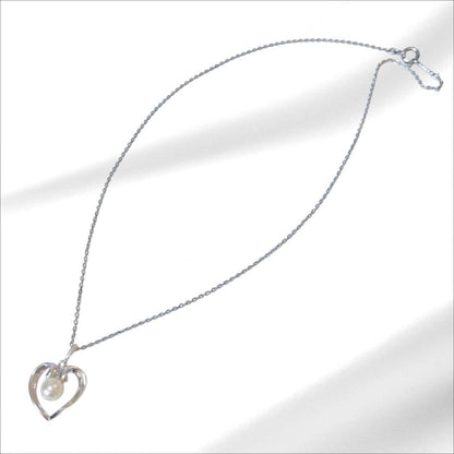 Mikimoto pearl necklace with silver heart pendant and 37 cm Akoya pearls on white background