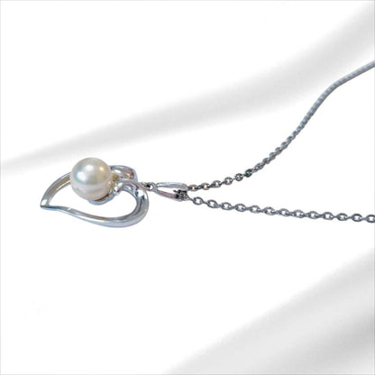 Mikimoto pearl necklace with silver heart pendant and 37 cm Akoya pearls on white background