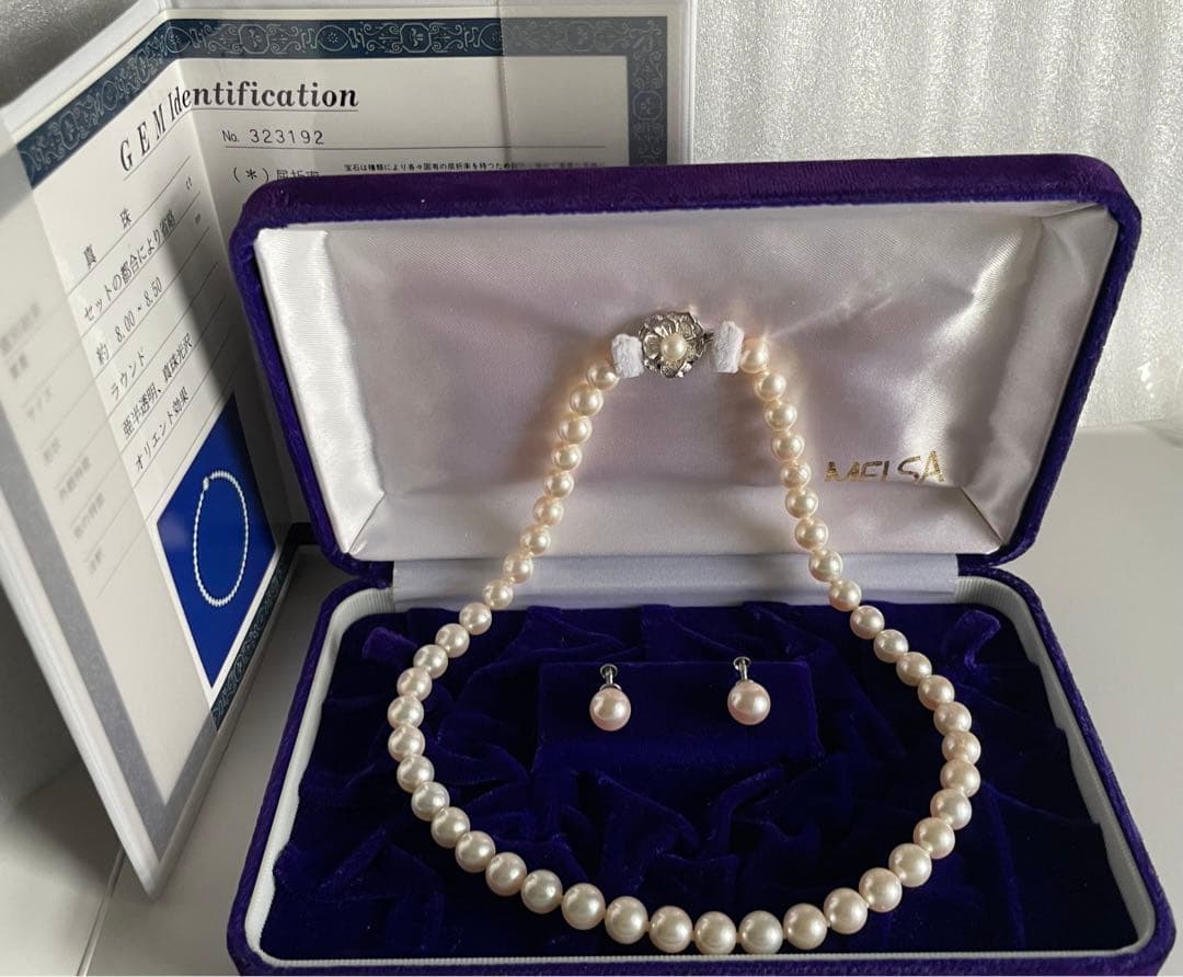 Akoya pearl necklace with approximately 43 cm length and matching round pearl screw-back earrings set on a white background