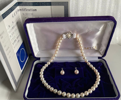 Akoya pearl necklace with approximately 43 cm length and matching round pearl screw-back earrings set on a white background