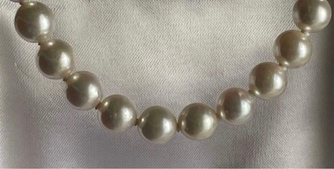 Akoya pearl necklace with approximately 43 cm length and matching round pearl screw-back earrings set on a white background