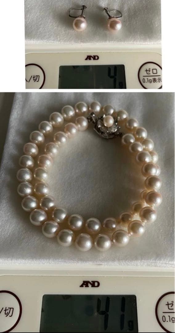 Akoya pearl necklace with approximately 43 cm length and matching round pearl screw-back earrings set on a white background