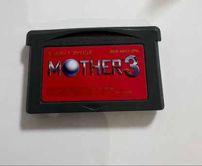Game Boy Advance MOTHER3 game cartridge with original box and manual showing signs of aging and storage damage