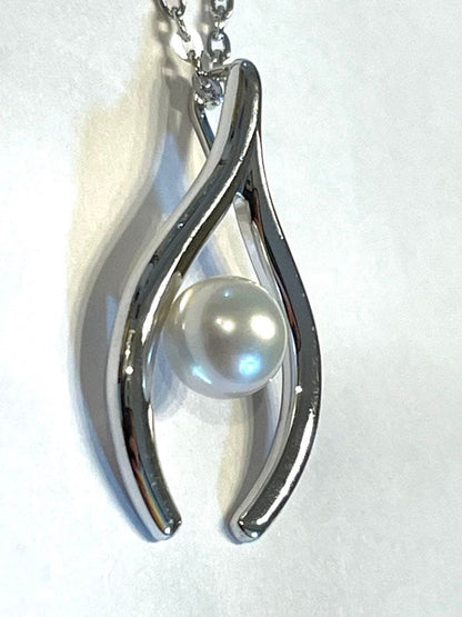 Mikimoto silver pearl necklace with 2.5 x 1.5 cm pendant and 39 cm chain on white background