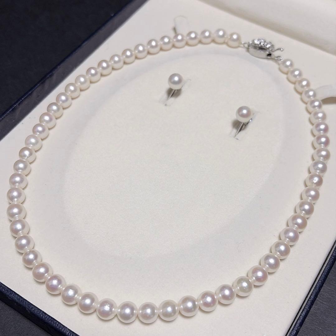 Akoya pearl necklace and matching earrings set with K14WG and silver clasps on white background
