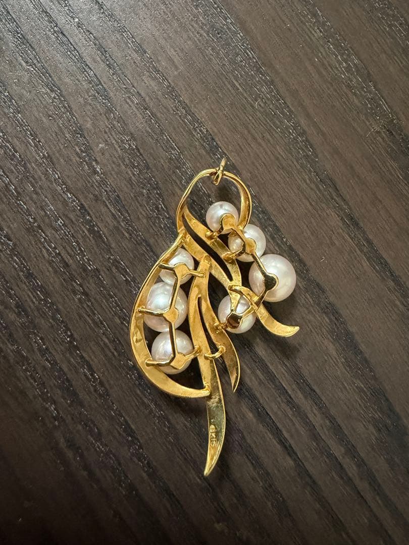 Mikimoto pearl necklace made of 18k gold with lustrous pearls on a white background