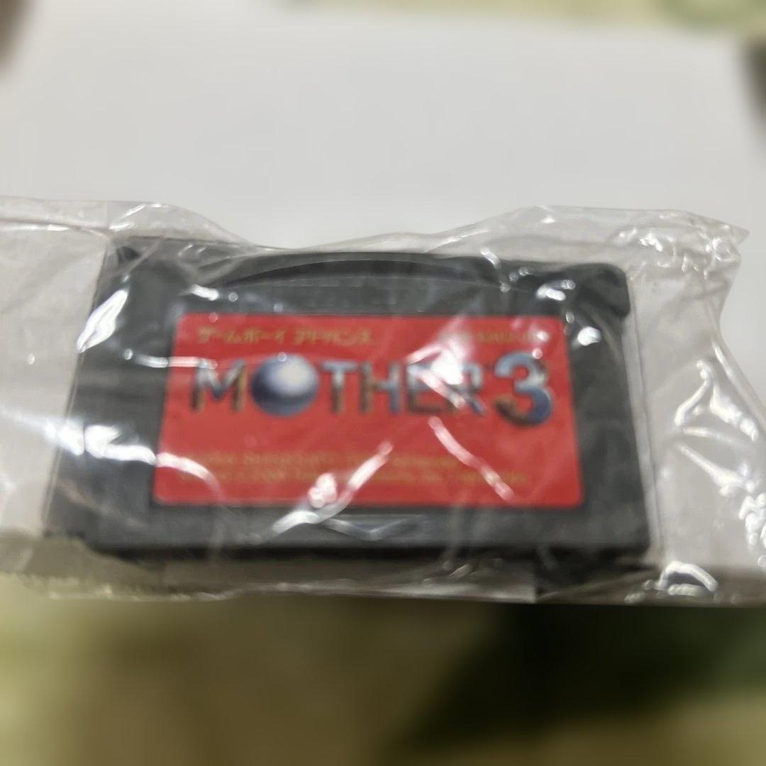 Game Boy Advance MOTHER3 game cartridge with original box and manual showing wear and aging signs