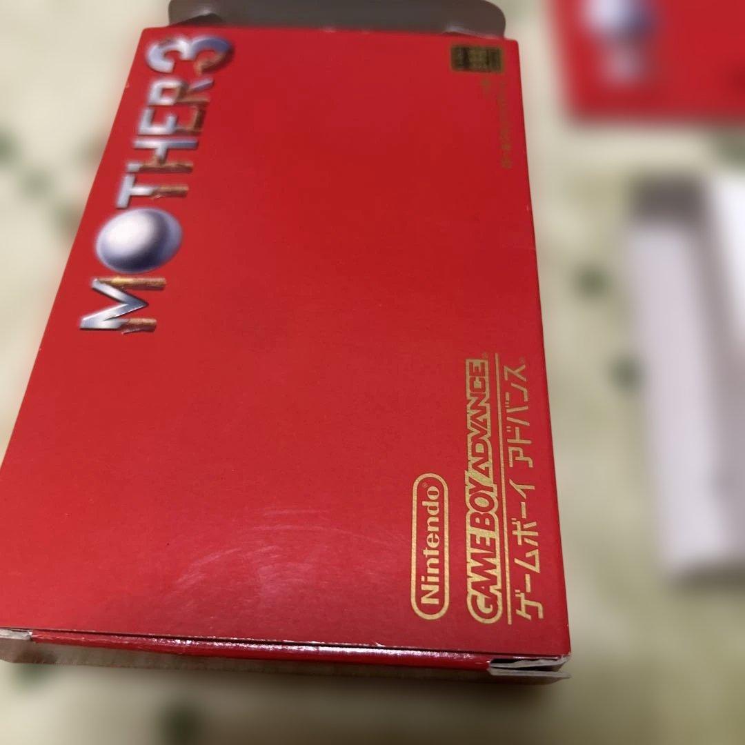 Game Boy Advance MOTHER3 game cartridge with original box and manual showing wear and aging signs