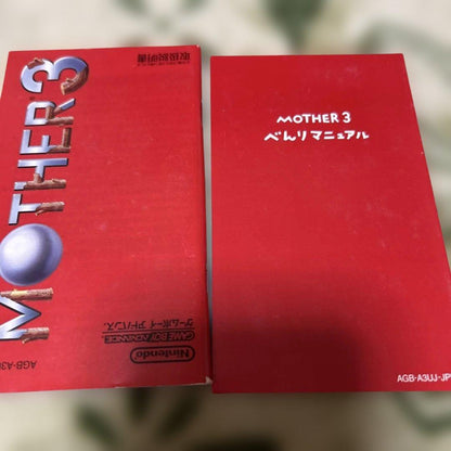 Game Boy Advance MOTHER3 game cartridge with original box and manual showing wear and aging signs