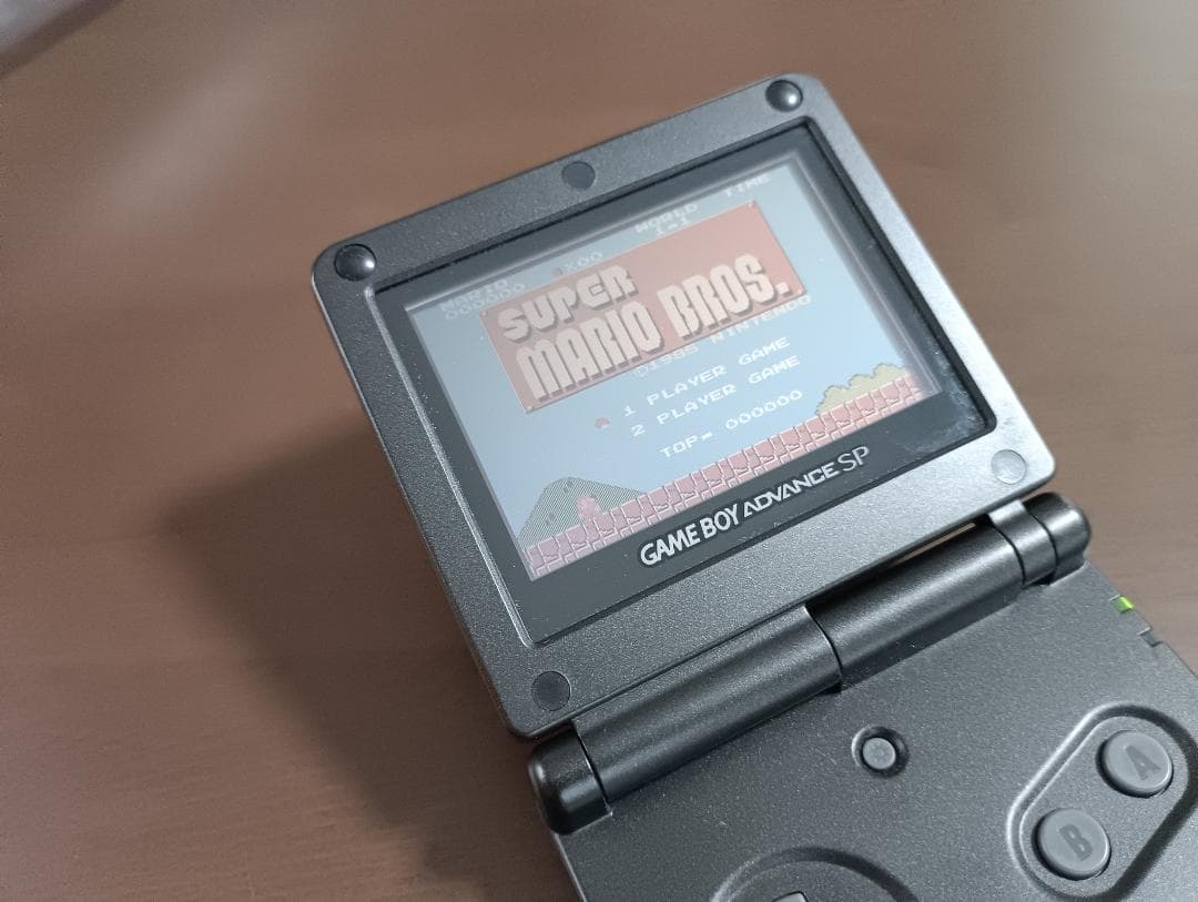 Famicom Mini Advance console with 8 classic game cartridges including Takahashi Meijin's Adventure Island and Bomberman