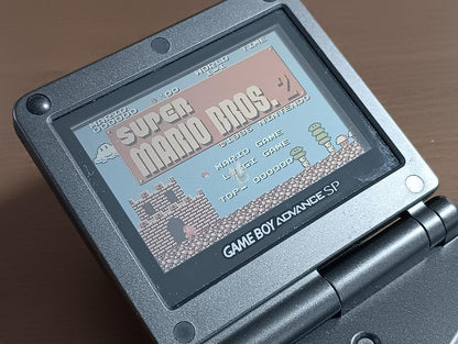 Famicom Mini Advance console with 8 classic game cartridges including Takahashi Meijin's Adventure Island and Bomberman