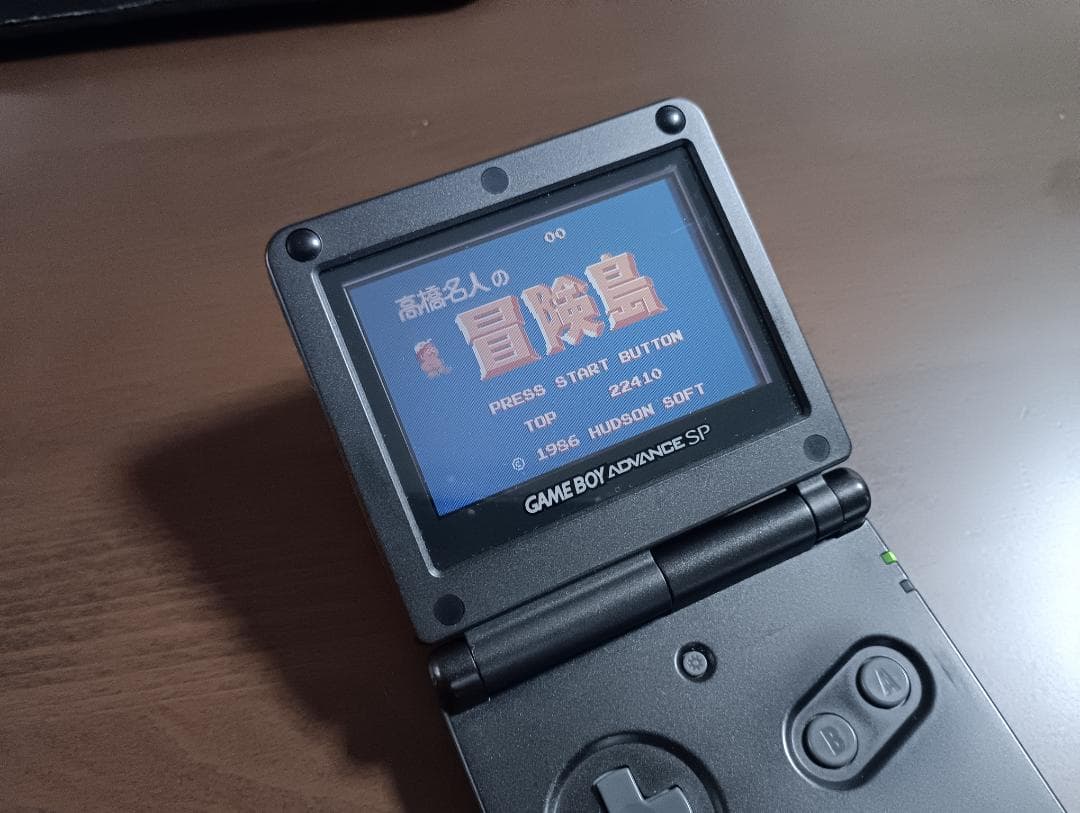 Famicom Mini Advance console with 8 classic game cartridges including Takahashi Meijin's Adventure Island and Bomberman