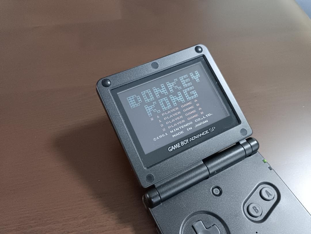 Famicom Mini Advance console with 8 classic game cartridges including Takahashi Meijin's Adventure Island and Bomberman