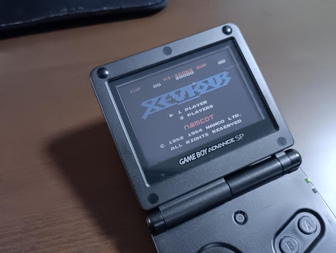 Famicom Mini Advance console with 8 classic game cartridges including Takahashi Meijin's Adventure Island and Bomberman