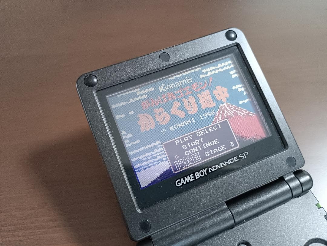 Famicom Mini Advance console with 8 classic game cartridges including Takahashi Meijin's Adventure Island and Bomberman