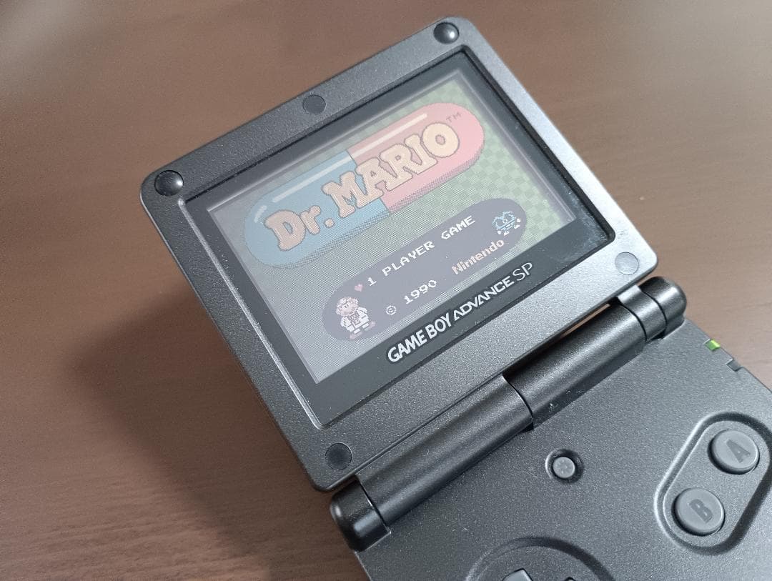 Famicom Mini Advance console with 8 classic game cartridges including Takahashi Meijin's Adventure Island and Bomberman
