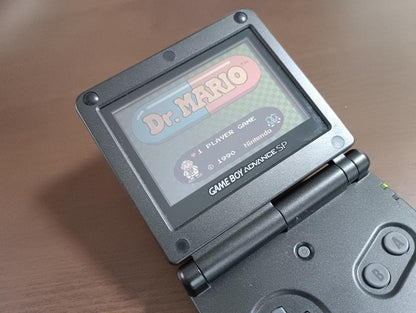 Famicom Mini Advance console with 8 classic game cartridges including Takahashi Meijin's Adventure Island and Bomberman